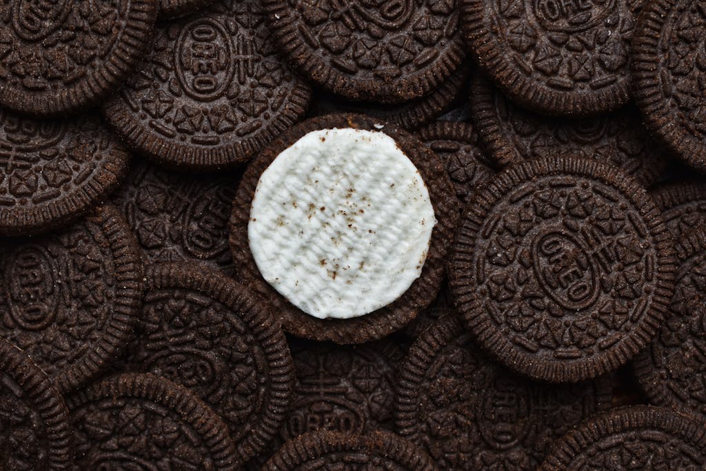 Delicious chocolate cream cookies stacked together with one missing cream top.