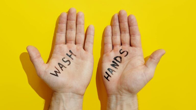 Two hands with 'wash hands' message on a bright yellow background, emphasizing hygiene and cleanliness.