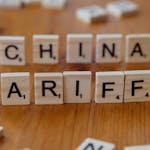 Scrabble tiles spelling 'China' and 'Tariffs' symbolize global trade issues.