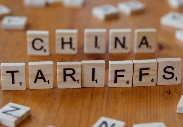 Scrabble tiles spelling 'China' and 'Tariffs' symbolize global trade issues.